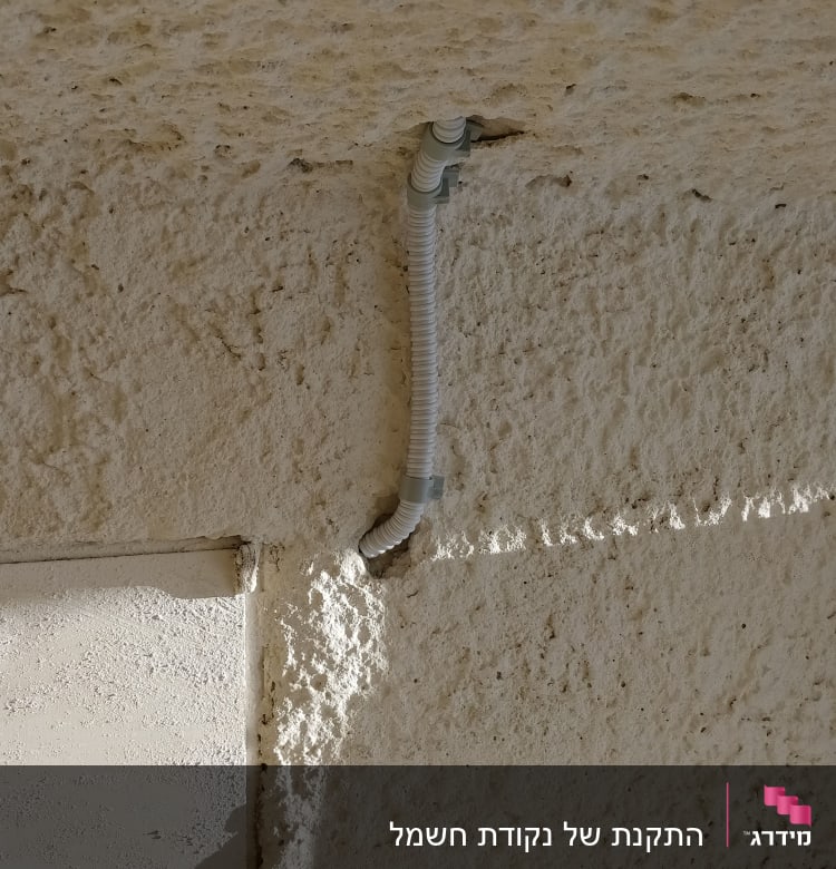צינור חשמל גמיש מותקן על קיר בטון